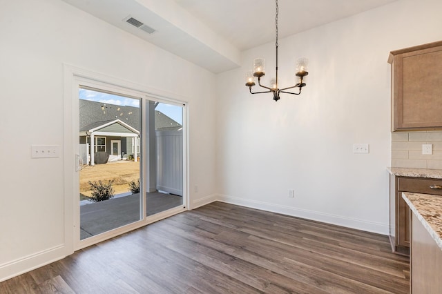 unfurnished dining area featuring a notable chandelier and dark hardwood / wood-style flooring