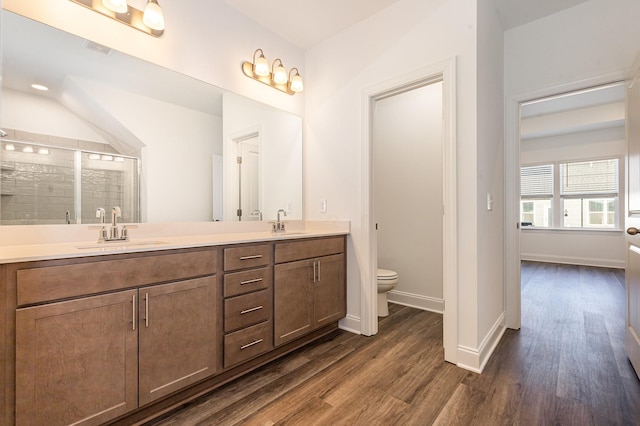 bathroom with vanity, toilet, hardwood / wood-style floors, and a shower with shower door