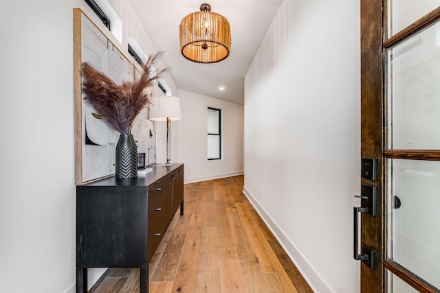 hall featuring light wood-style floors and baseboards