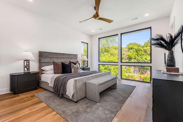 bedroom featuring a ceiling fan, wood finished floors, visible vents, and recessed lighting