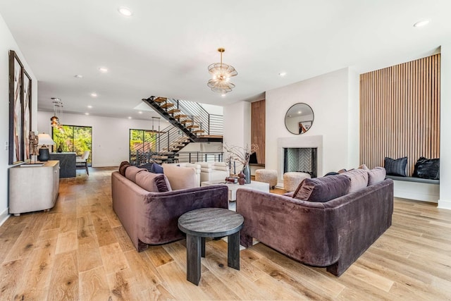 living room featuring light wood finished floors, stairway, a chandelier, and recessed lighting