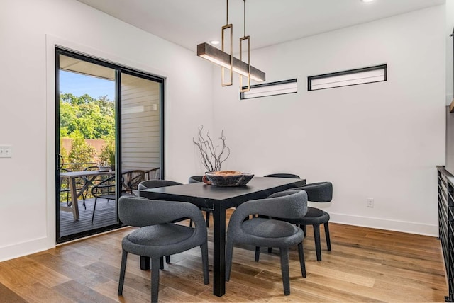 dining space with baseboards, wood finished floors, and recessed lighting