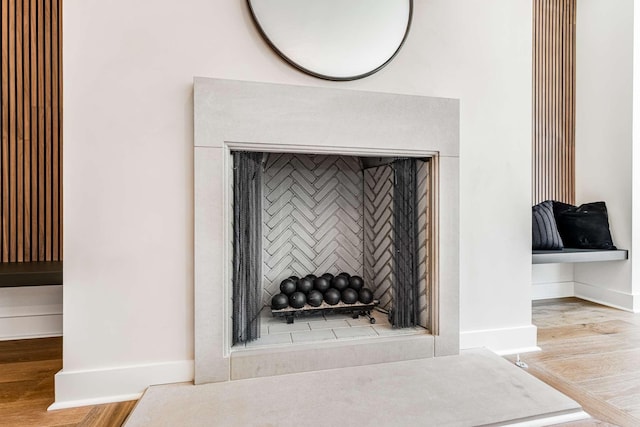 interior details featuring a fireplace, baseboards, and wood finished floors