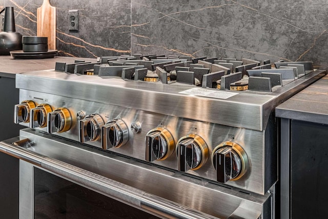 interior details with stainless steel range and decorative backsplash