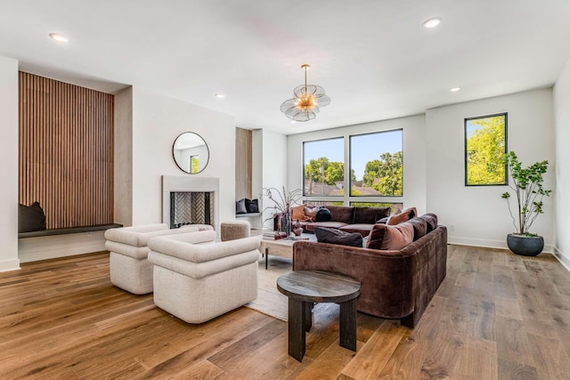 living room featuring light wood-type flooring, a fireplace, and recessed lighting