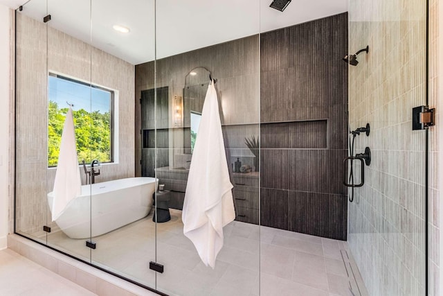 full bathroom featuring tile patterned flooring, a soaking tub, a shower stall, and tile walls