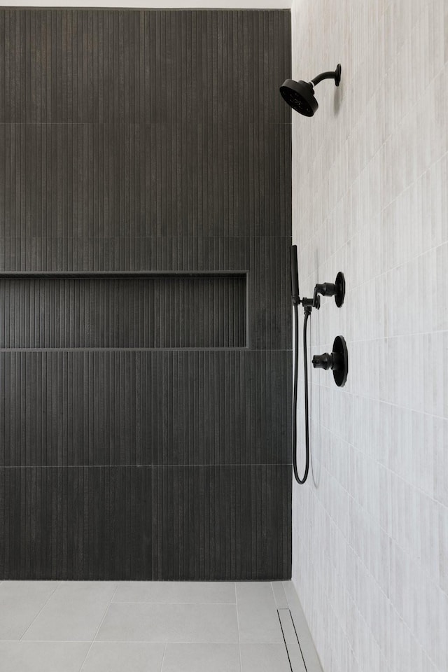 bathroom featuring tiled shower and tile patterned flooring