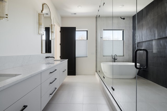 full bath featuring double vanity, a stall shower, visible vents, a soaking tub, and tile patterned flooring