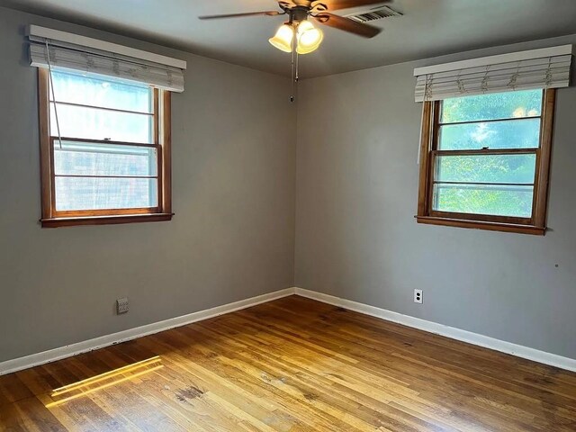 unfurnished room featuring hardwood / wood-style flooring, plenty of natural light, and ceiling fan