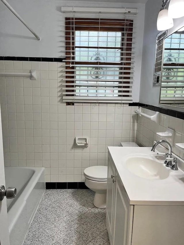 bathroom featuring vanity, toilet, and tile walls