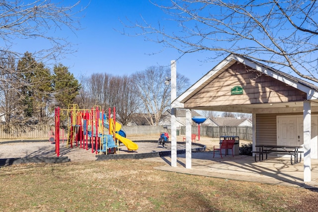 view of playground featuring a patio area, an outdoor fire pit, and a lawn