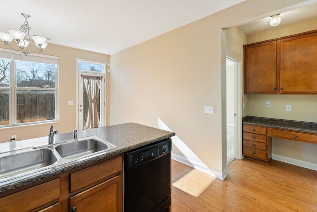 kitchen with dishwasher, built in desk, decorative light fixtures, light hardwood / wood-style floors, and sink