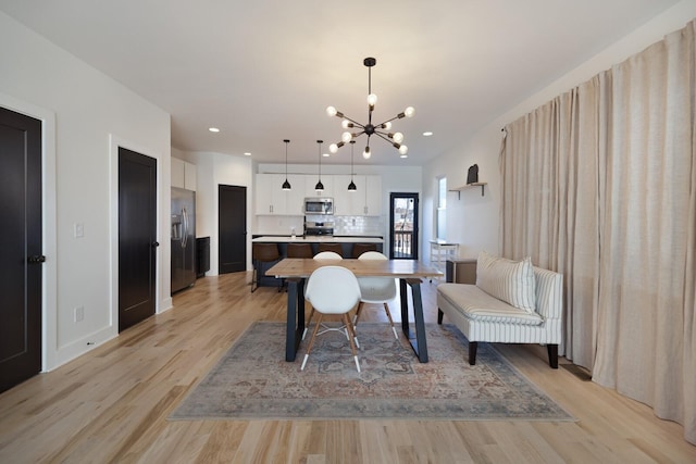 living room with light hardwood / wood-style floors and a notable chandelier