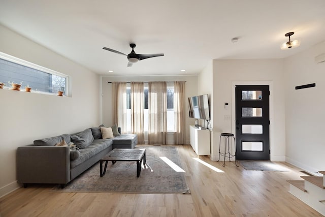 living room with ceiling fan and light wood-type flooring