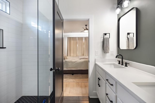 bathroom with a tile shower, tile patterned flooring, and vanity