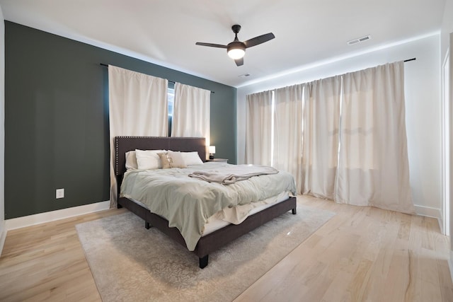 bedroom with light hardwood / wood-style floors and ceiling fan