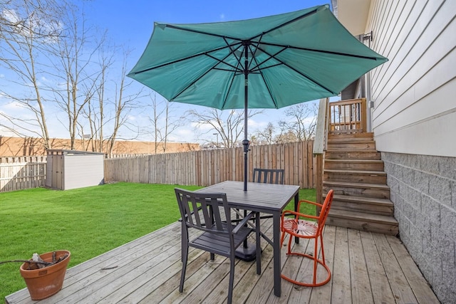 wooden terrace featuring a yard and a storage shed