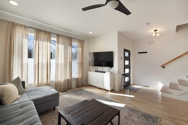 living room with ceiling fan and light hardwood / wood-style flooring