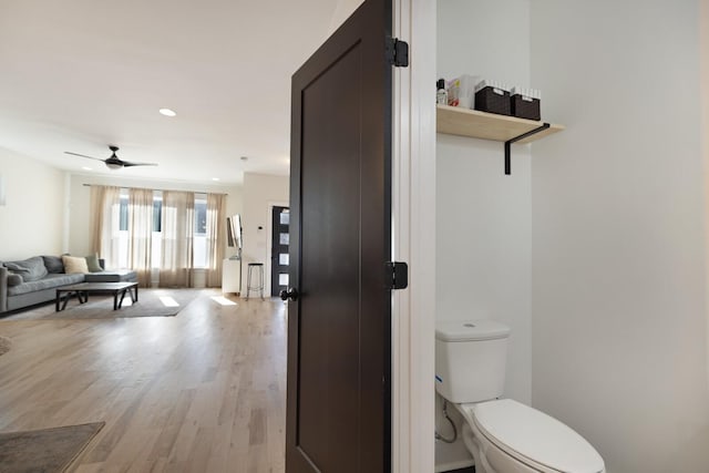 bathroom with hardwood / wood-style floors, toilet, and ceiling fan