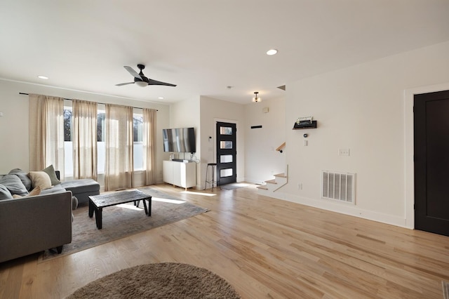 living room with light wood-type flooring and ceiling fan