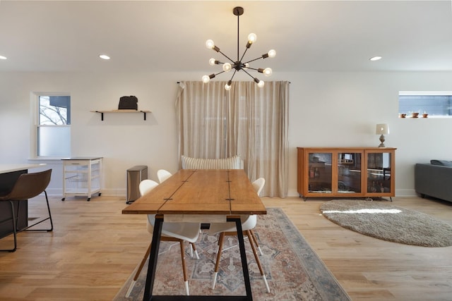 dining area featuring light hardwood / wood-style flooring and a chandelier