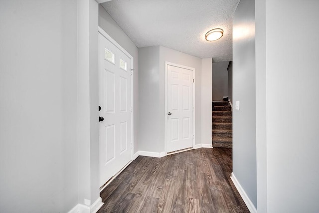 entryway featuring dark wood-type flooring and a textured ceiling