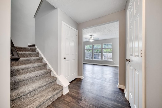 staircase with hardwood / wood-style floors, a textured ceiling, and ceiling fan