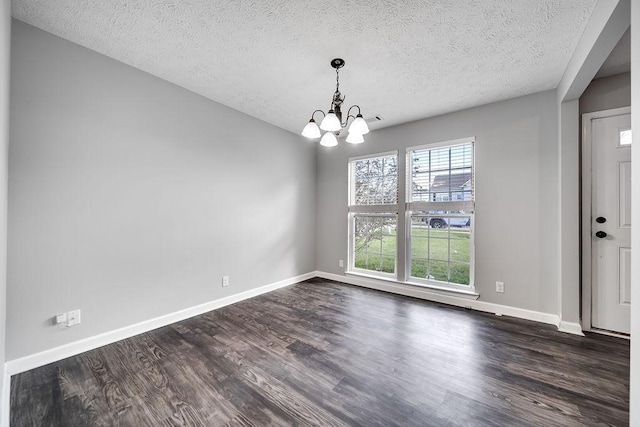 unfurnished dining area with a textured ceiling, dark hardwood / wood-style floors, and a notable chandelier