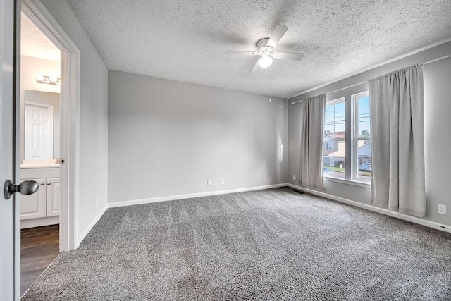 carpeted spare room featuring ceiling fan and a textured ceiling