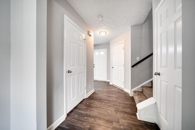 hallway with dark wood-type flooring and a textured ceiling