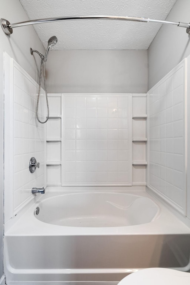 bathroom featuring  shower combination, a textured ceiling, and toilet