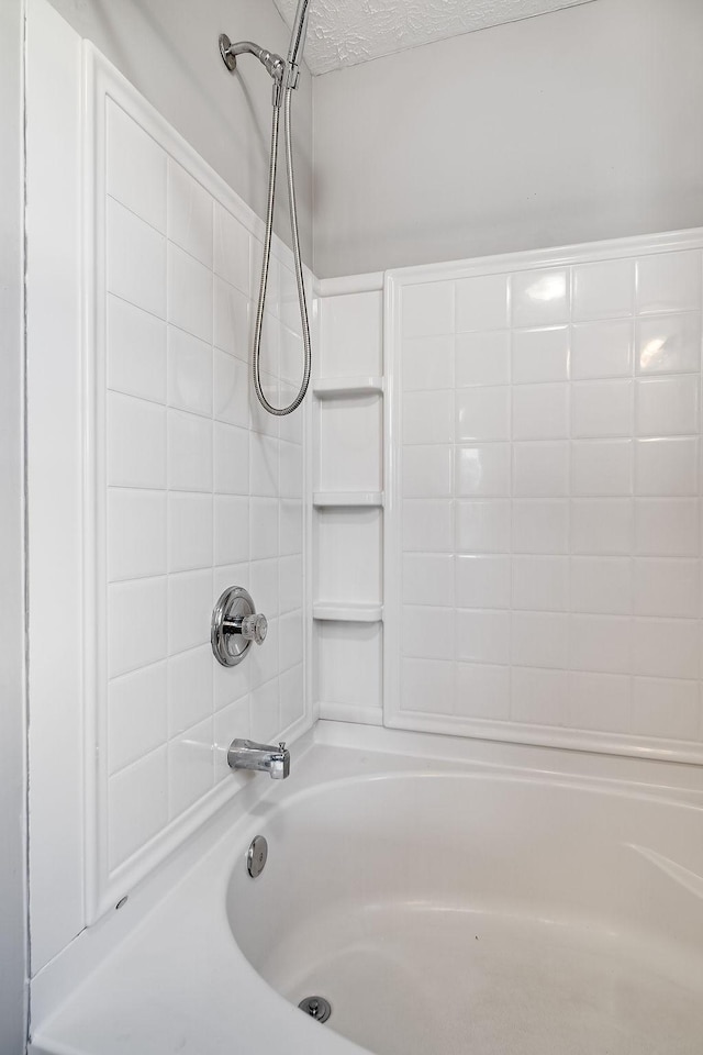 bathroom featuring a textured ceiling and  shower combination