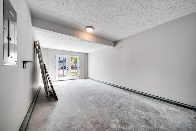 unfurnished room featuring a textured ceiling, beam ceiling, and french doors