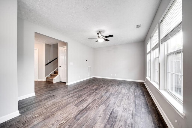 empty room featuring ceiling fan, dark hardwood / wood-style floors, and a textured ceiling