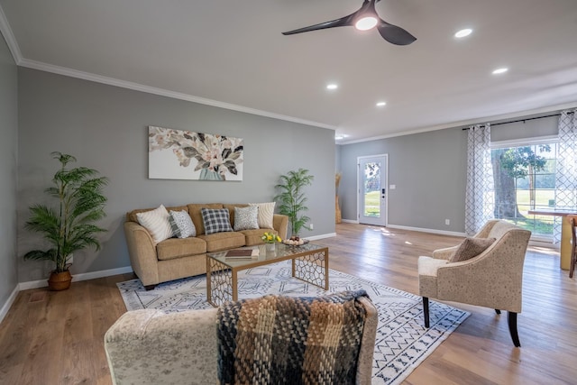 living room with crown molding, ceiling fan, and light wood-type flooring