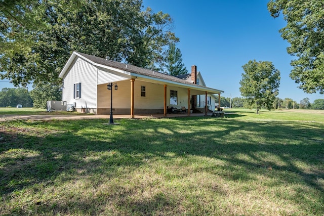 rear view of house featuring a yard