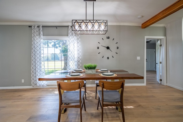 dining area featuring crown molding, light hardwood / wood-style floors, and beamed ceiling