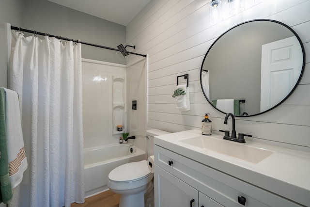 full bathroom with hardwood / wood-style floors, wooden walls, vanity, toilet, and shower / bath combo with shower curtain