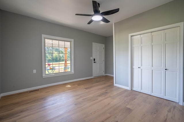 unfurnished bedroom with light hardwood / wood-style floors, a closet, and ceiling fan