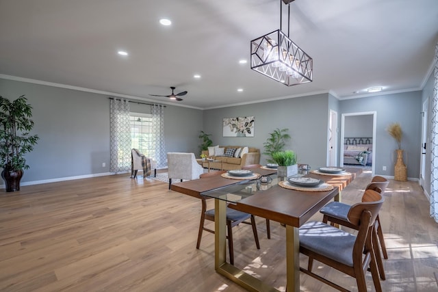 dining space featuring ceiling fan with notable chandelier, ornamental molding, and light hardwood / wood-style floors