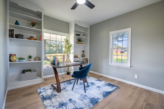 home office with light hardwood / wood-style flooring and ceiling fan