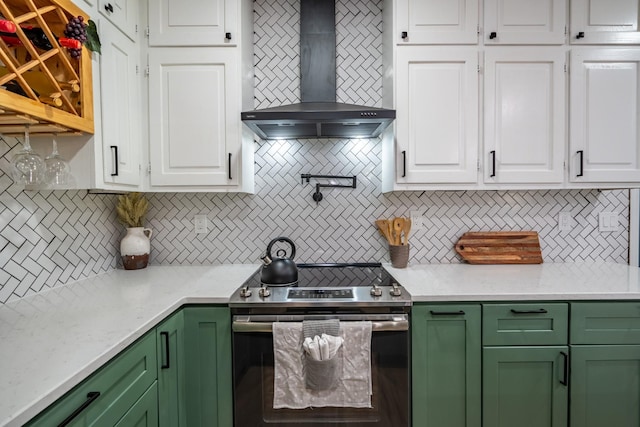 kitchen featuring backsplash, stainless steel electric stove, white cabinets, and wall chimney exhaust hood