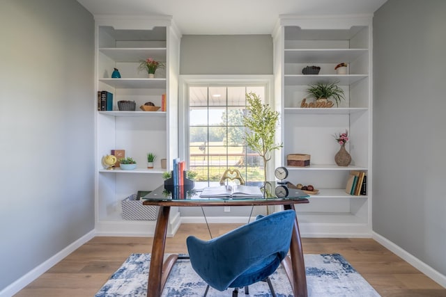 office area with built in shelves and light wood-type flooring