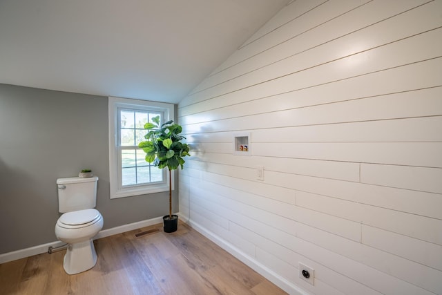 bathroom featuring hardwood / wood-style flooring, lofted ceiling, and toilet