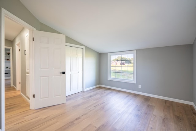 interior space featuring a closet, lofted ceiling, and light hardwood / wood-style flooring