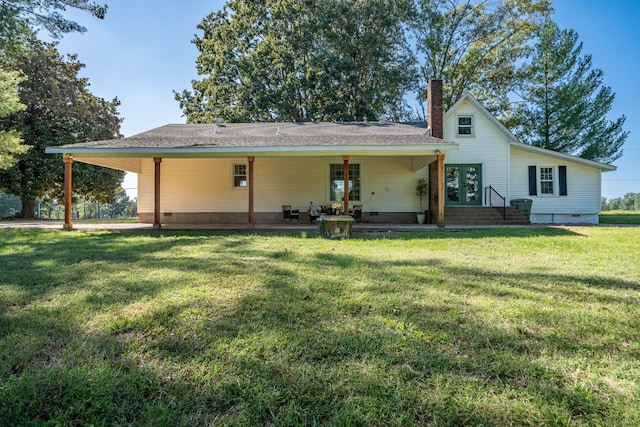 back of property featuring a yard and french doors