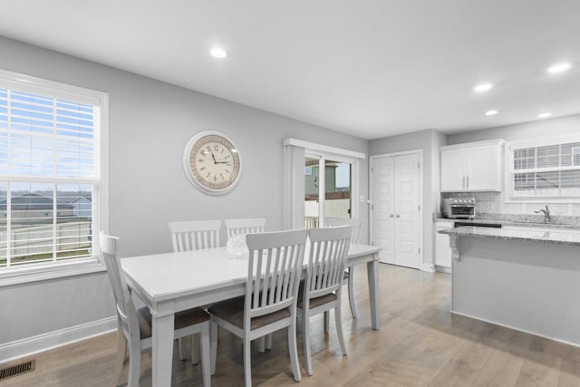 dining area with sink and light wood-type flooring