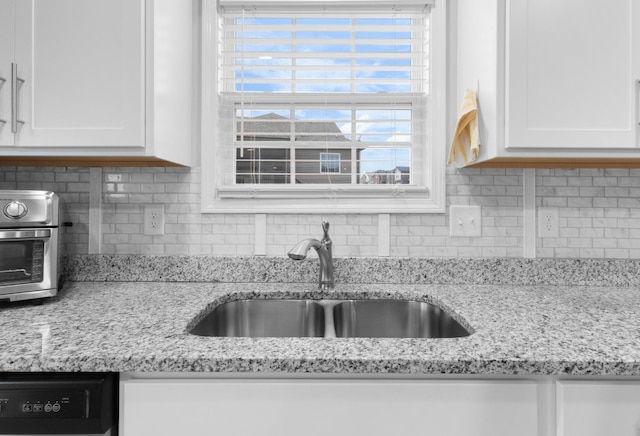 kitchen with sink, white cabinetry, backsplash, and dishwasher