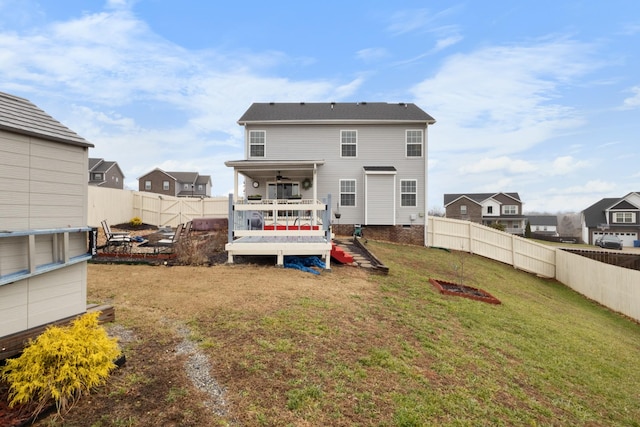 back of property with a wooden deck and a lawn