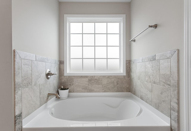 bathroom with a tub to relax in and a wealth of natural light